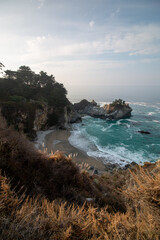 Iconic McWay Falls Cascading onto a Secluded Beach in a Turquoise Cove at Sunset in Big Sur, California
