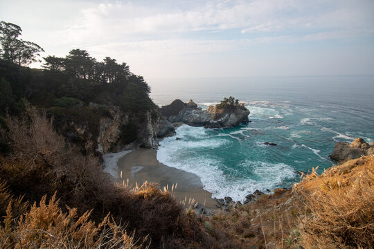 Iconic McWay Falls Cascading onto a Secluded Beach in a Turquoise Cove at Sunset in Big Sur, California