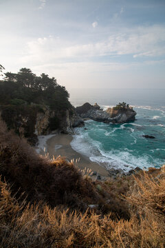 Iconic McWay Falls Cascading onto a Secluded Beach in a Turquoise Cove at Sunset in Big Sur, California