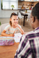 Child engages in creative drawing with attentive mentor indoors