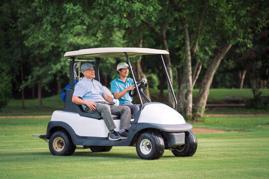 Young man driving golf cart while chatting happily with senior golfer. Golf Cart Ride, Outdoor Golf, Summer Activity.