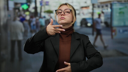 Woman meditating with a calm expression on a bustling city street adorned with blurred crowds and vibrant signs, capturing the essence of mindfulness amidst urban chaos.