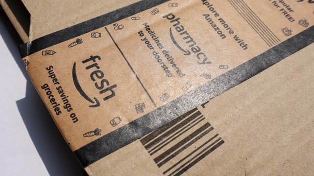 Amazon delivery parcel brown box. Amazon labeled with mini tv, fresh, pharmacy