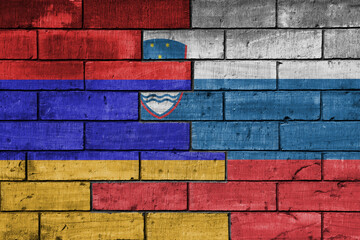colourful painted big national flag of slovenia and flag of armenia on a massive old brick wall background. concept