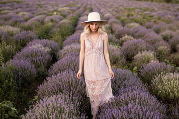 A serene scene featuring a woman in a lavender field, gracefully dressed in a lace outfit and hat,...