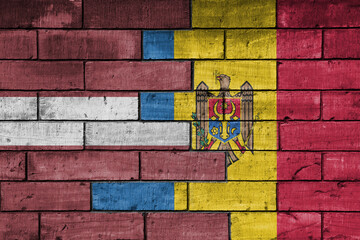 colourful painted big national flag of moldova and flag of latvia on a massive old brick wall background. concept