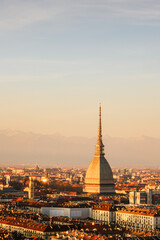 Vertical shot of the city of Turin (Torino) during sunset. Mole Antonelliana and Alps mountains on background. Piedmont, Italy