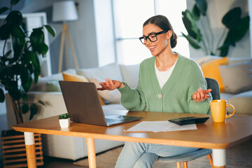 Young woman enjoying a casual day at home during daylight while interacting happily and relaxing in...