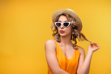 A fashionable woman wearing white sunglasses and a straw hat gazes stylishly, embodying summer vibes and trendy aesthetics. © kegfire