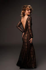 A sophisticated woman elegantly poses in a lace evening gown, exuding charm and style. Ideal...