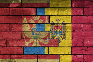 colourful painted big national flag of moldova and flag of montenegro on a massive old brick wall background. concept