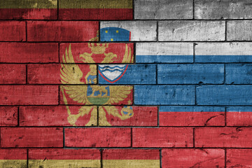 colourful painted big national flag of slovenia and flag of montenegro on a massive old brick wall background. concept