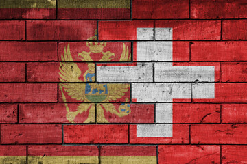 colourful painted big national flag of switzerland and flag of montenegro on a massive old brick wall background. concept