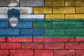 colourful painted big national flag of lithuania and flag of slovenia on a massive old brick wall background. concept