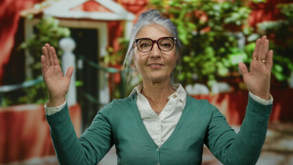 Elderly woman with grey hair using hand gestures on a vibrant street backdrop, showcasing confidence and expressiveness outdoors in an urban setting.