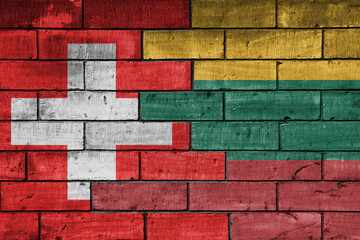 colourful painted big national flag of lithuania and flag of switzerland on a massive old brick wall background. concept