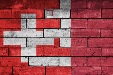 colourful painted big national flag of malta and flag of switzerland on a massive old brick wall background. concept