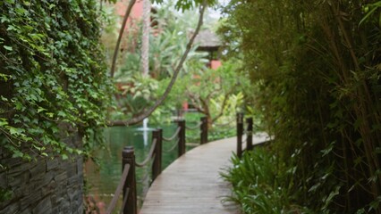 Fototapeta premium Tropical resort with wooden pathway amidst lush greenery and flowing water evokes luxury and tranquility
