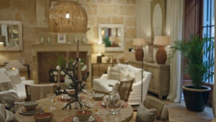 Living room with blurred decor, featuring bokeh lighting, rustic furniture, warm tones, and elegant dining table, creating a cozy, inviting indoor ambiance at home.