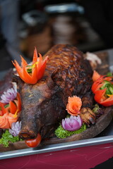 Roasted pork garnished with various fruits and vegetables