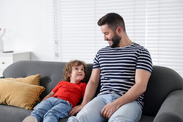 Obraz premium Happy father and his son spending time together on sofa at home