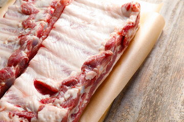 Raw pork ribs on wooden table, closeup