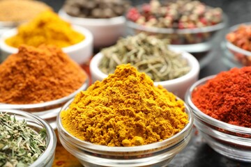 Different aromatic spices in bowls on table, closeup