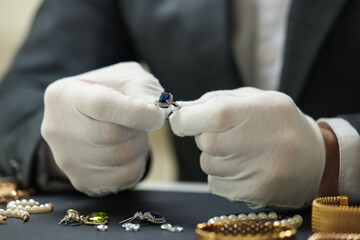 Appraiser working with luxury ring at table, closeup