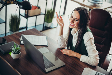 Confident businesswoman in office workspace using laptop, expressing friendly communication and...