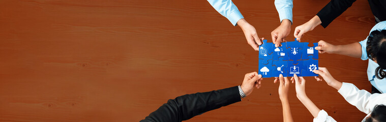 A group engages in collaborative teamwork, using colorful puzzle pieces to represent various computing concepts during a dynamic meeting session aimed at innovative solutions. Amity