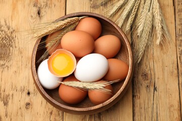 Fresh eggs and spikes on wooden table, flat lay