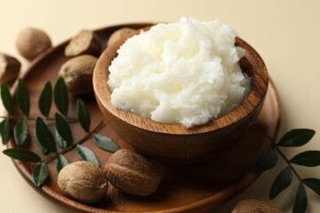 She butter, nuts and leaves on beige background, closeup