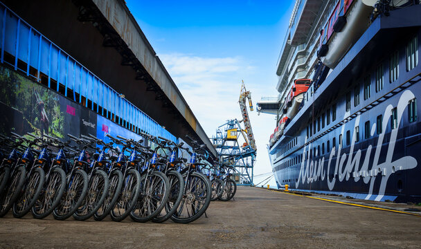 Eine Gruppe ordentlich aufgestellter Mountainbikes auf dem Reynolds Pier in Ochos Rios, Jamaica; auf der rechten Seite der Pier hat ein Schiff der TUI Cruises Flotte festgemacht