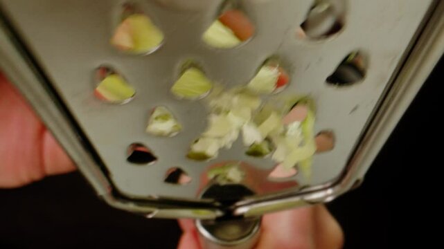 Green radish grater, Peeled Margelan radish rubbed on a vegetable grater, close up. 