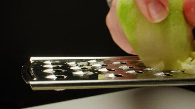 Green radish grater, Peeled Margelan radish rubbed on a vegetable grater, close up. 