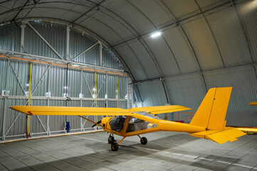 Yellow airplane glider in the hangar. 