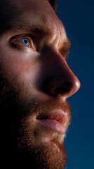 Contemplative Bearded Man Gazing into Distance against a Deep Blue Sky