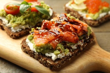 Different delicious avocado sandwiches on table, closeup