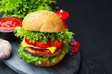 Delicious hamburger with patty served on black table, closeup. Space for text