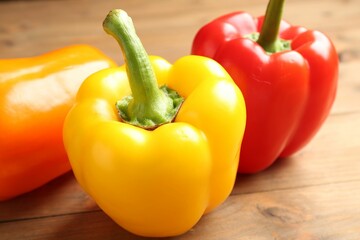 Ripe colorful bell peppers on wooden table, closeup