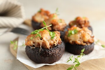 Tasty stuffed mushrooms served on light table, closeup
