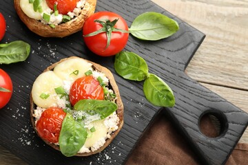 Tasty stuffed mushrooms served on wooden table, top view