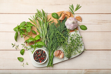 Different fresh herbs and spices on white wooden table, flat lay