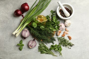Different herbs and spices on grey table, flat lay