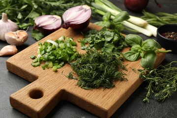 Different herbs and spices on black table, closeup