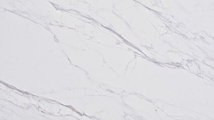 The smooth surface of white marble showcases delicate gray veining, ideal for countertops, flooring, and elegant decor in homes and businesses