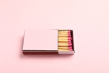 Matches in box on pink background, closeup. Mockup for design