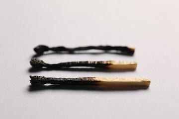 Burnt matches on grey background, closeup view