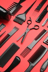 Different hairdresser's tools on red background, above view