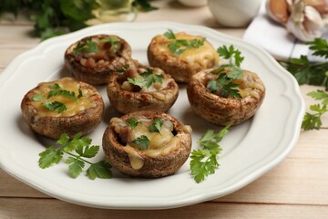 Tasty stuffed mushrooms served on wooden table, closeup